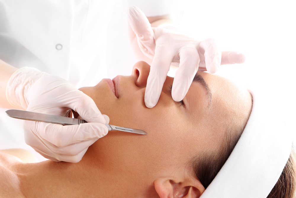 an expert is gently dermaplaning a patient's face to enhance their appearance 